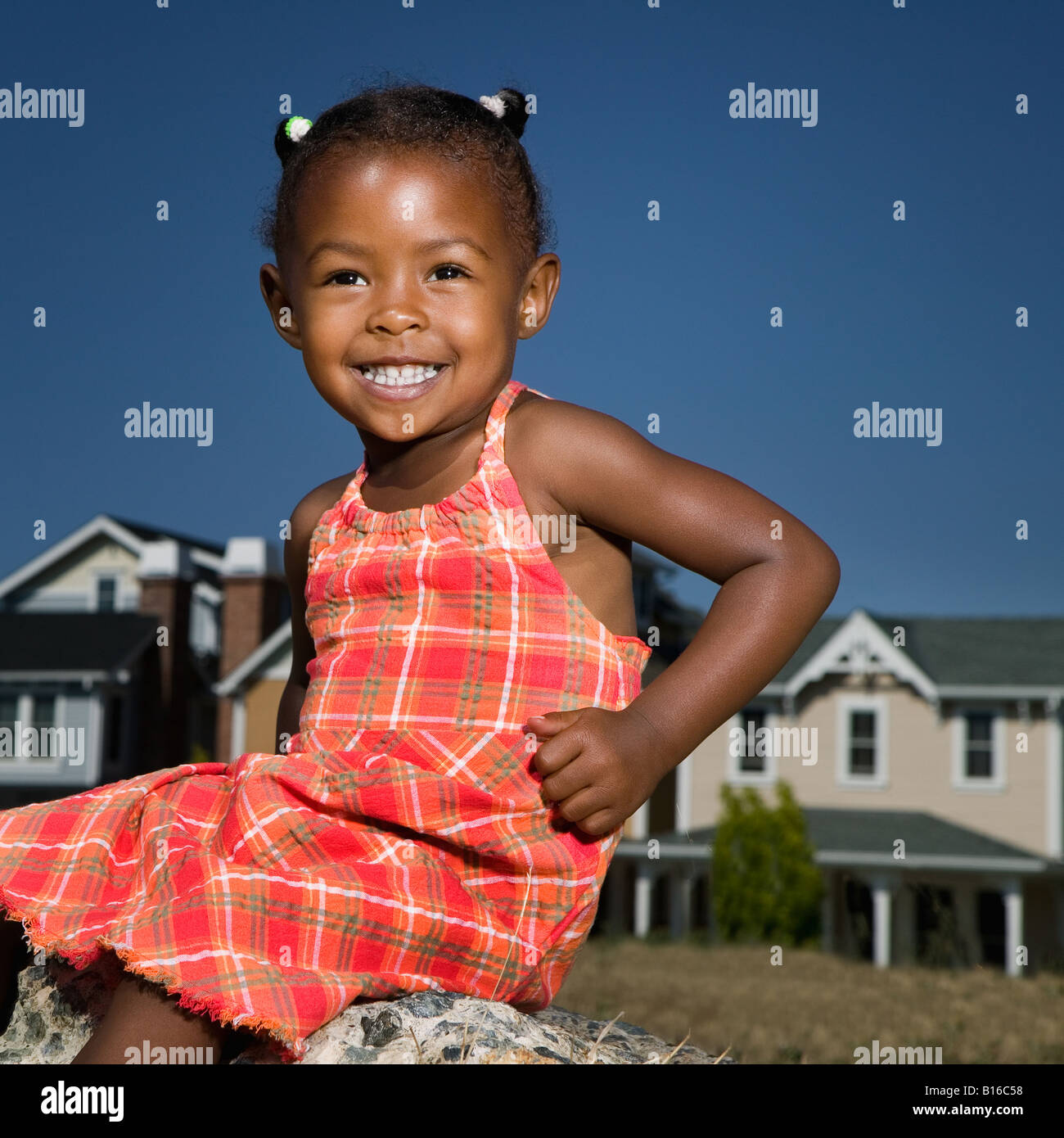 African American girl sitting on rock Stock Photo Alamy