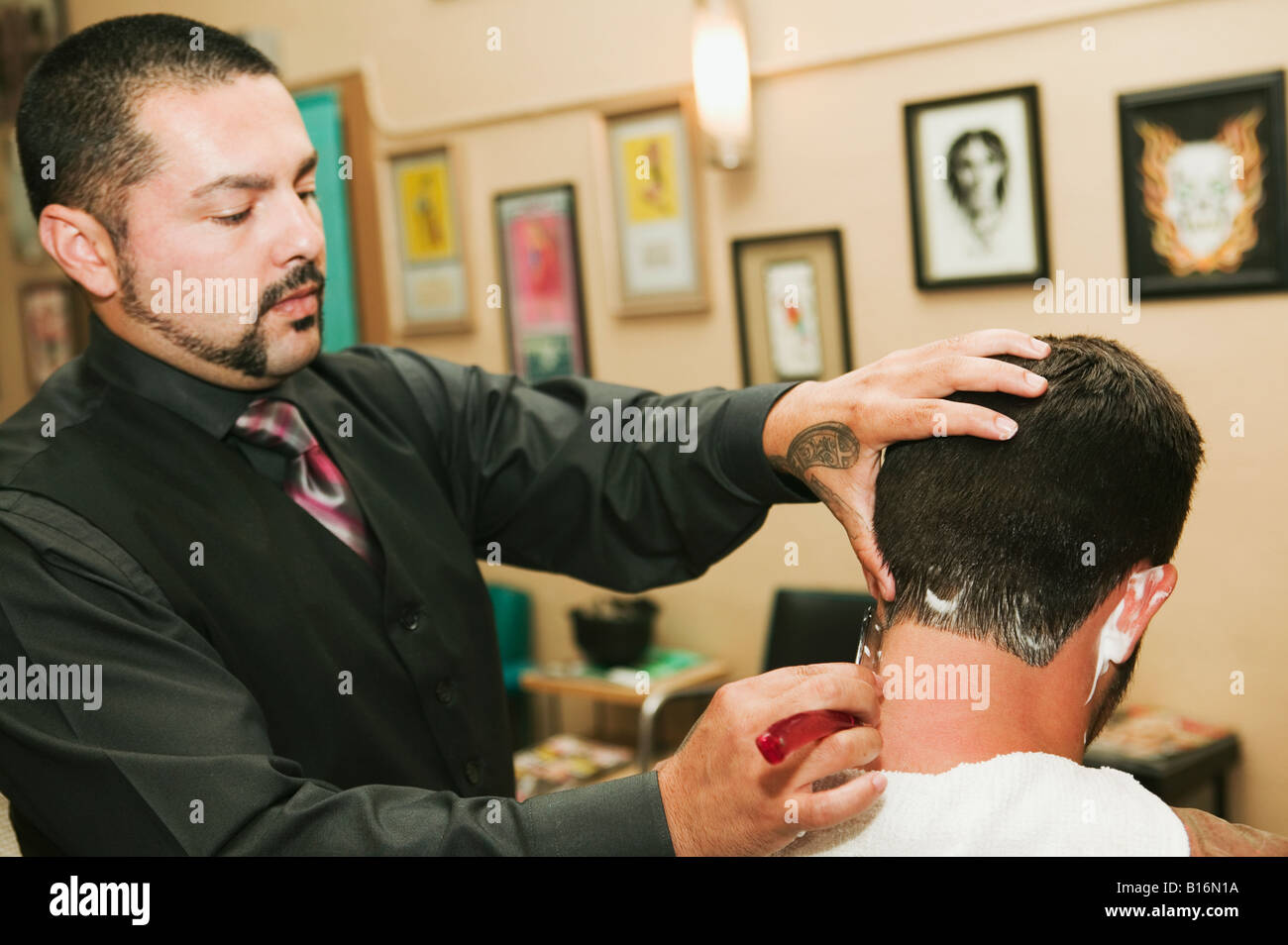 Hispanic barber shaving man’s neck Stock Photo Alamy