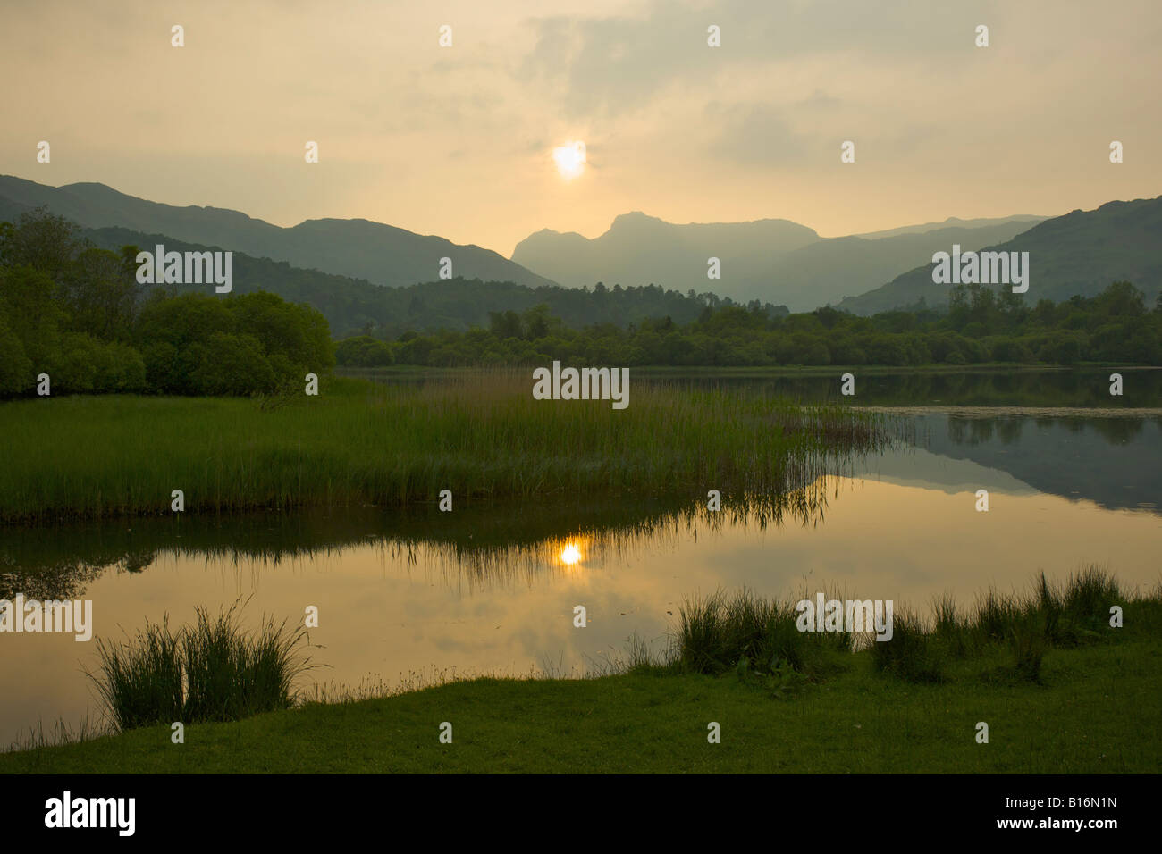 Hazy sunset over Elter Water and Langdale Pikes, Langdale Valley, Lake District National Park, Cumbria, England UK Stock Photo