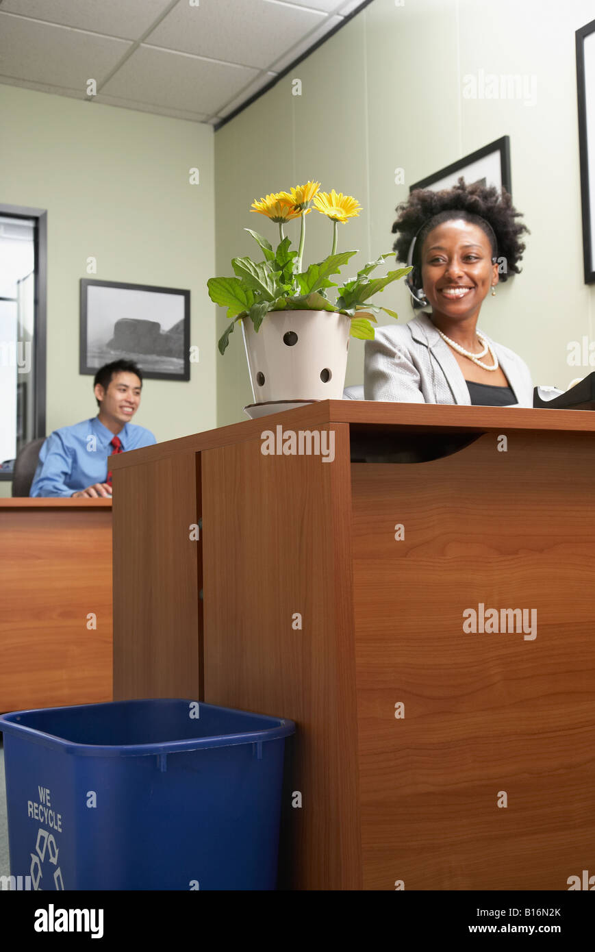 African businesswoman looking at plant Stock Photo