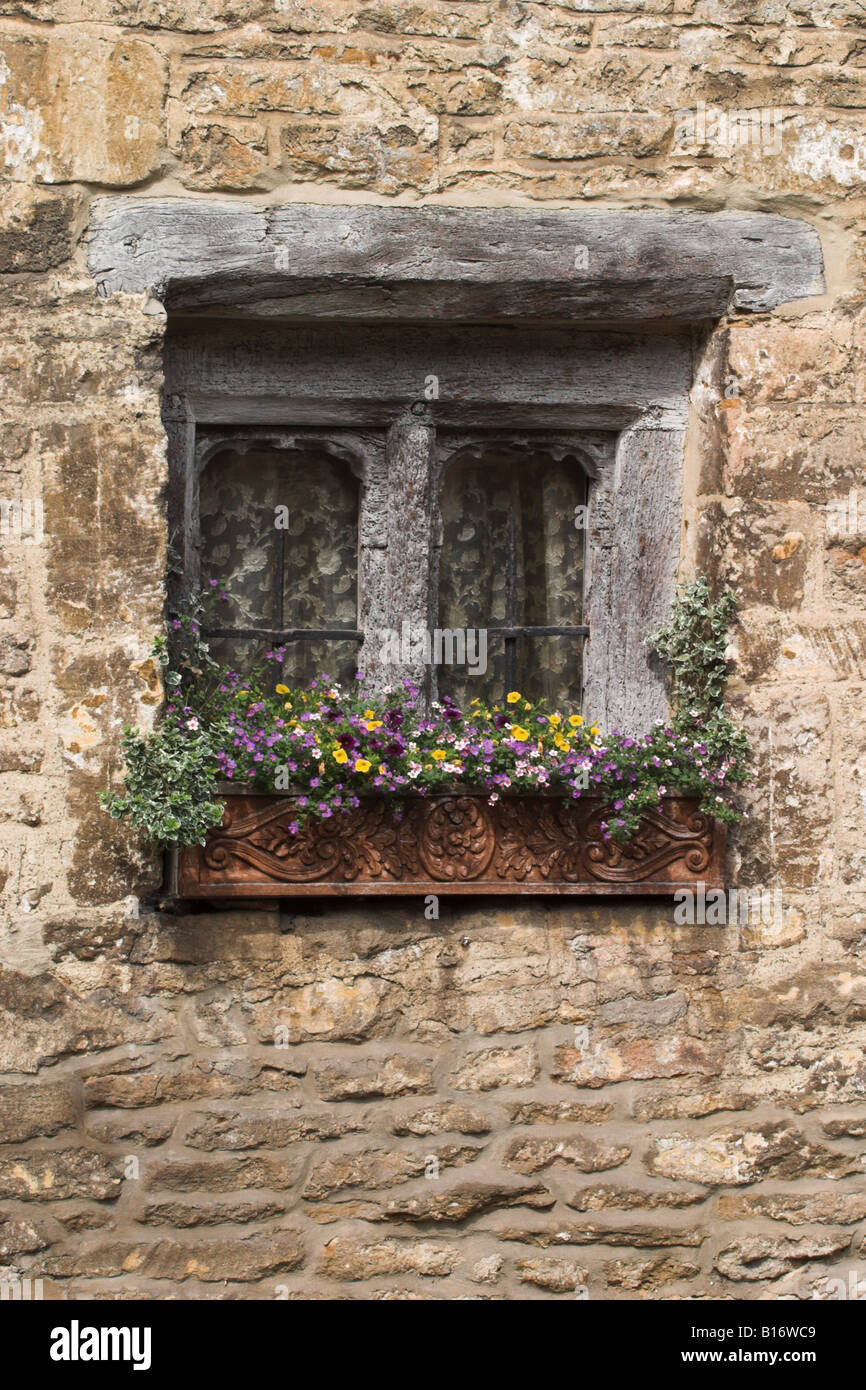 Old cottage window with window box filled with flowers, Castle Combe,The Cotswolds, Wiltshire, England Stock Photo