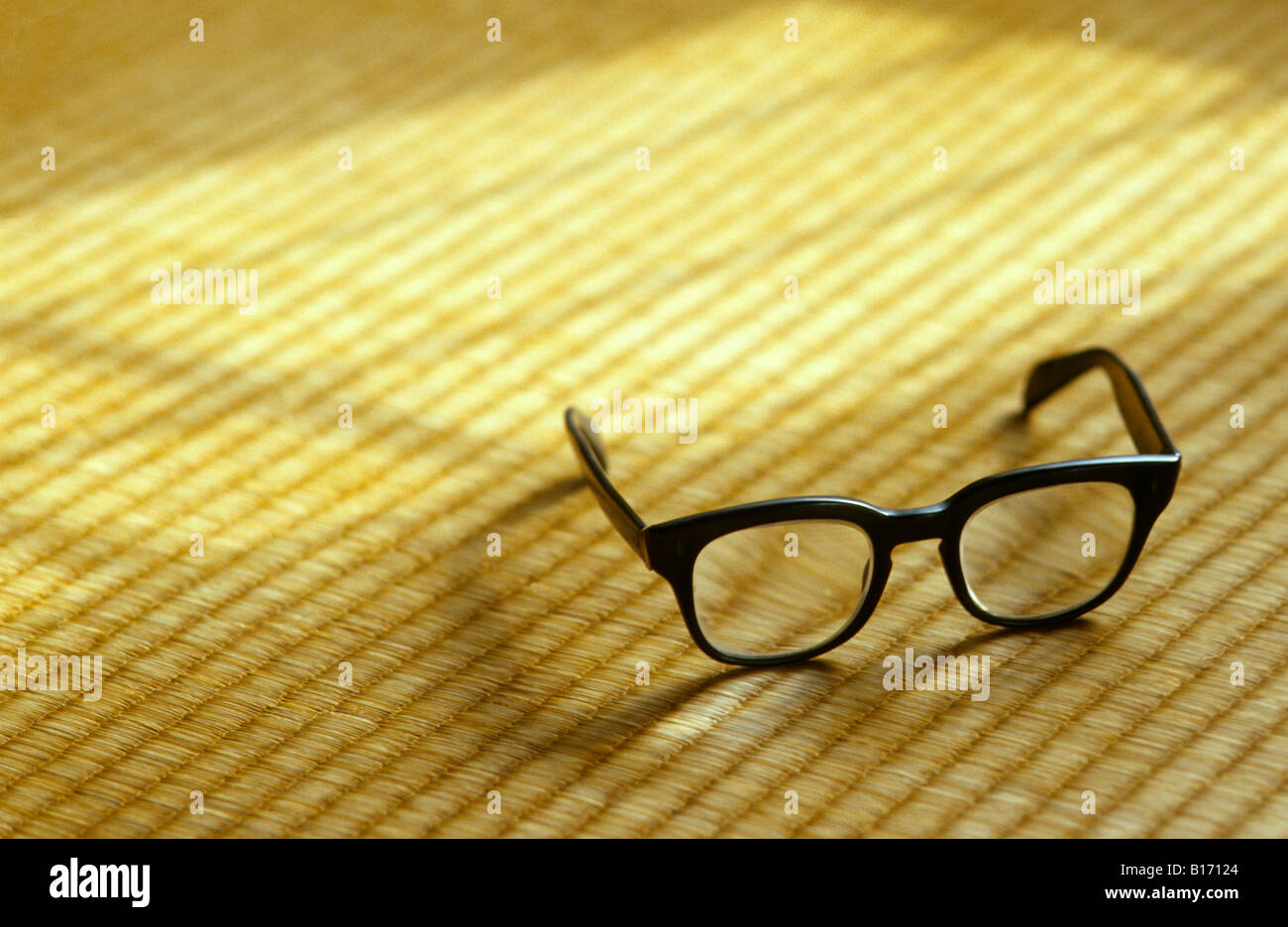 old thick black glasses on tatami with window light Stock Photo
