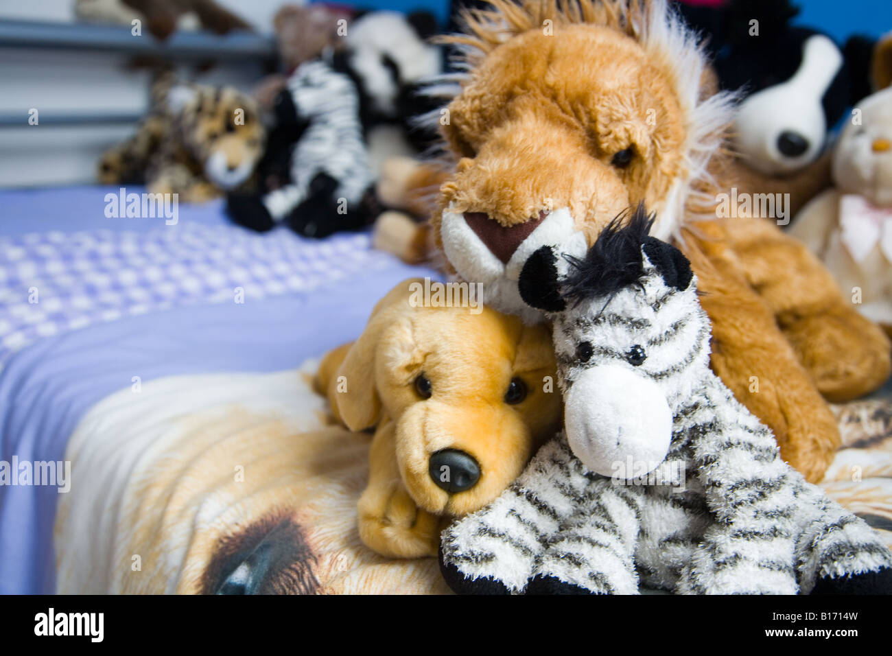 soft cuddly toys - dog, lion and zebra - on a bed Stock Photo