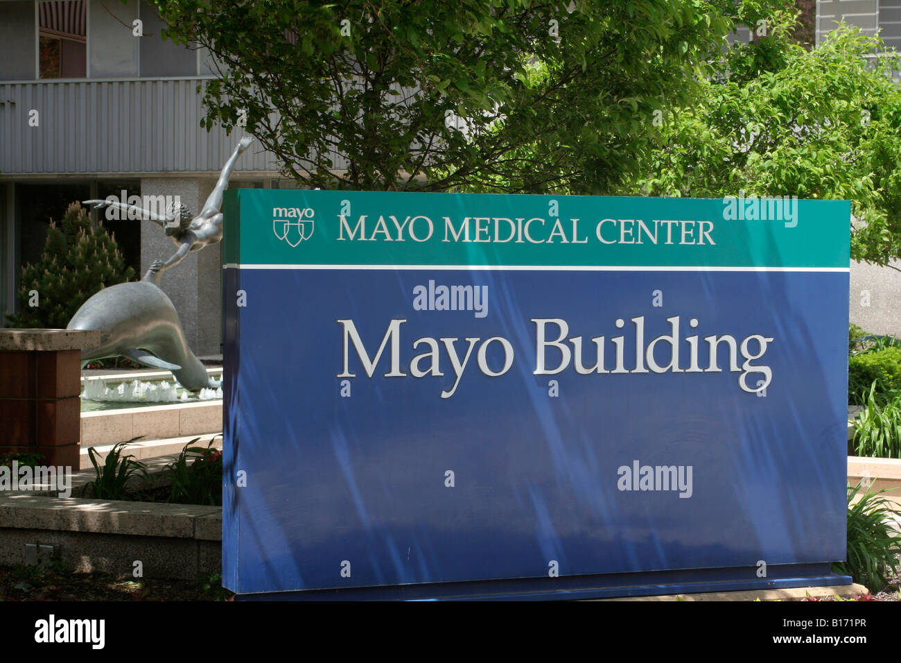 Sign for Mayo building with bronze sculpture of boy and dolphin in background Mayo medical complex in Rochester Minnesota Stock Photo