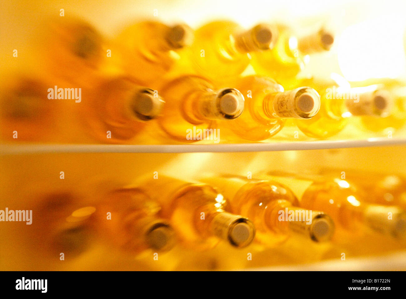 Bottles of white wine in a fridge, blurred Stock Photo Alamy