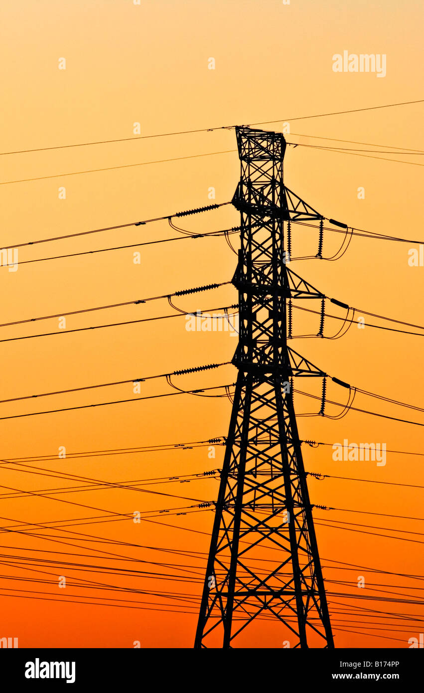 Energy Industry / Electricity. A High voltage Transmission Tower silhouetted at sunset. Stock Photo