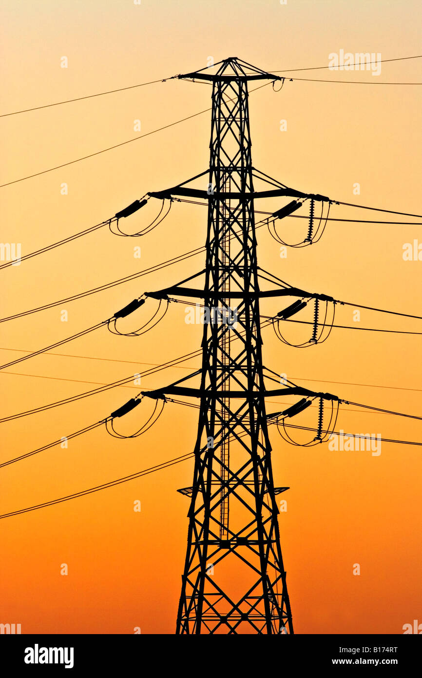 Energy Industry / High voltage Transmission Towers silhouetted at sunset. Stock Photo