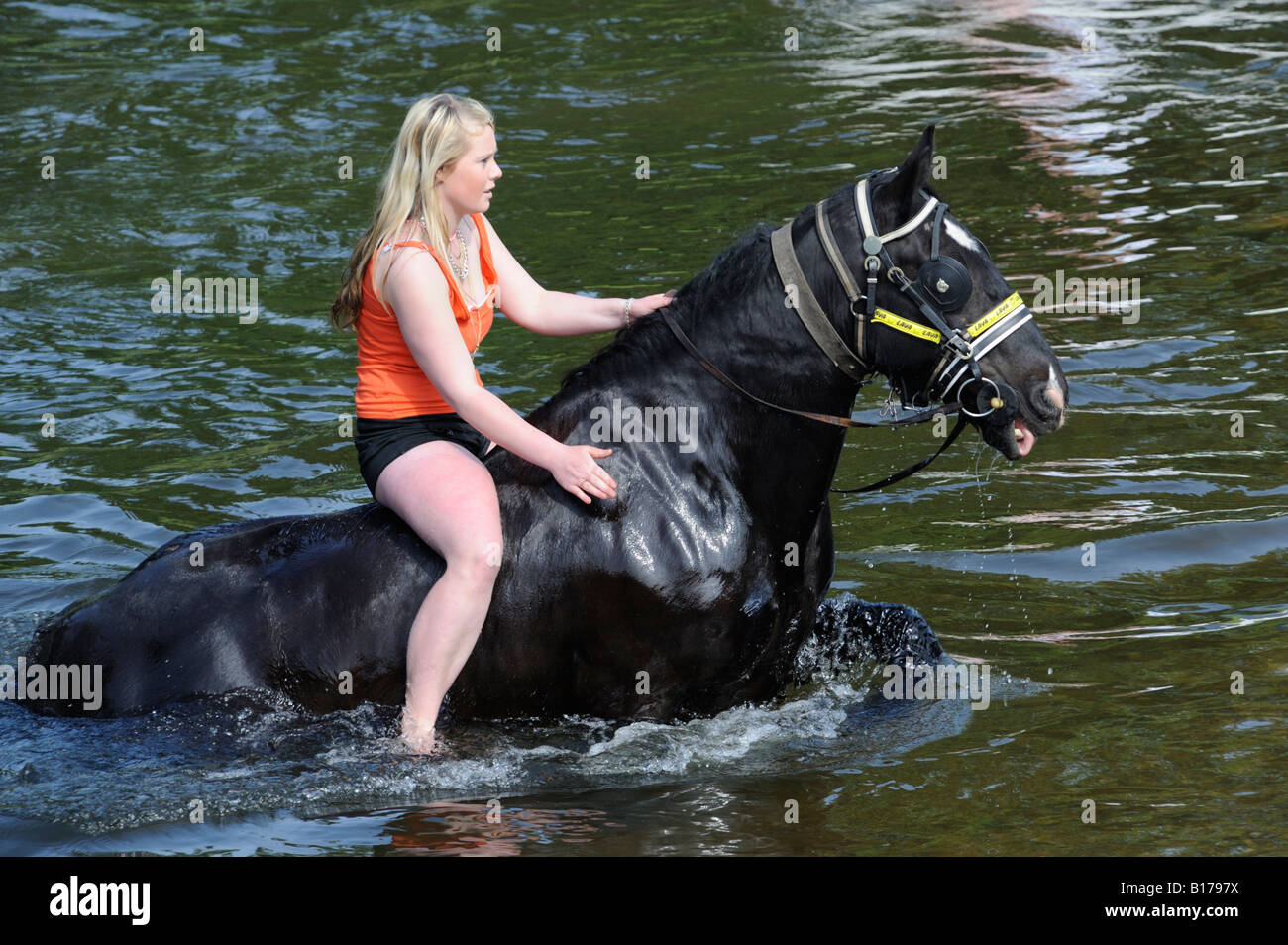 Gypsy traveller girl riding horse in River Eden. Appleby Horse Fair. Appleby-in-Westmorland, Cumbria, England, United Kingdom.. Stock Photo