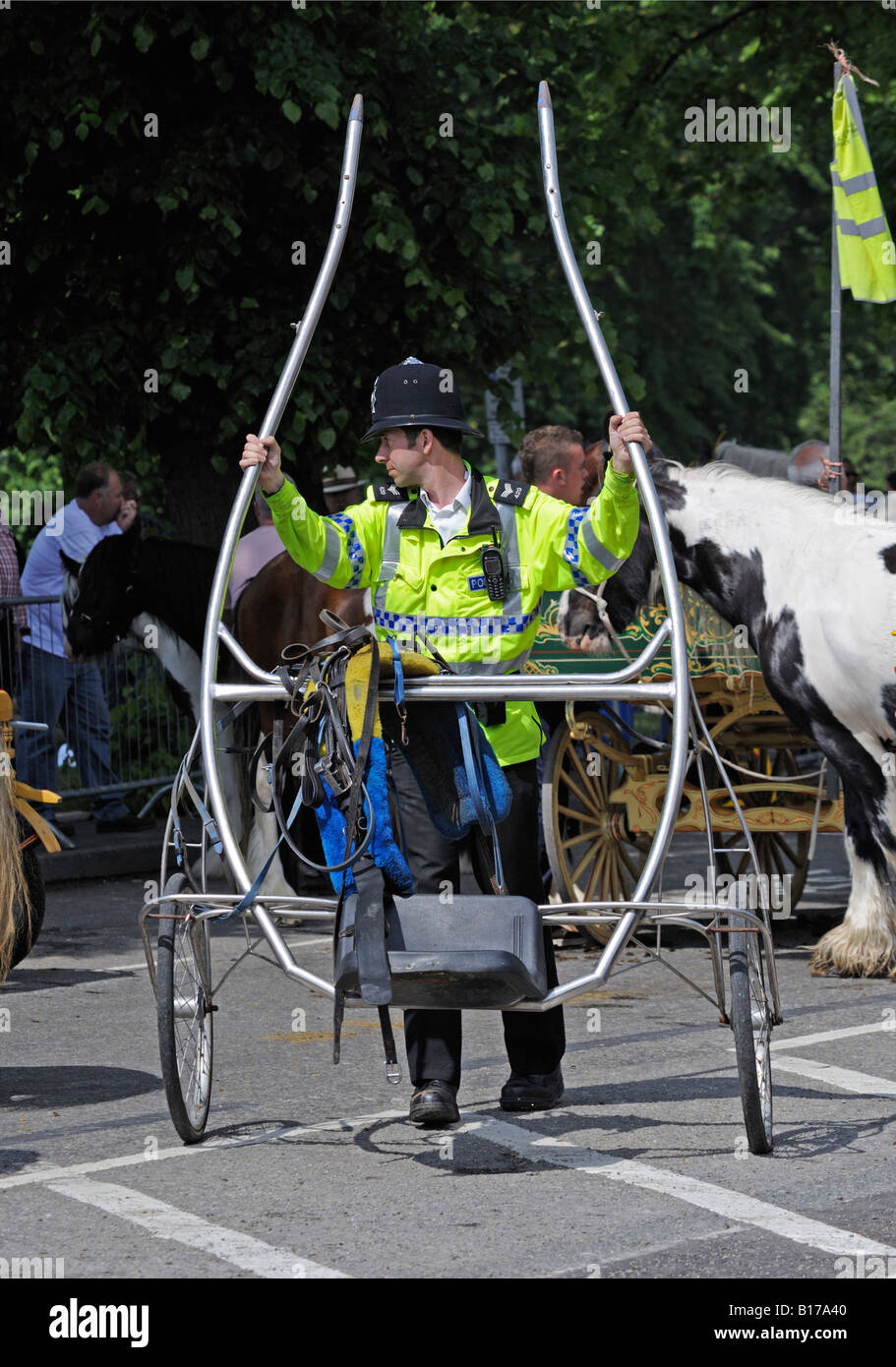 Policeman moving a trotting cart. Appleby Horse Fair. Appleby-in-Westmorland, Cumbria, England, United Kingdom, Europe. Stock Photo