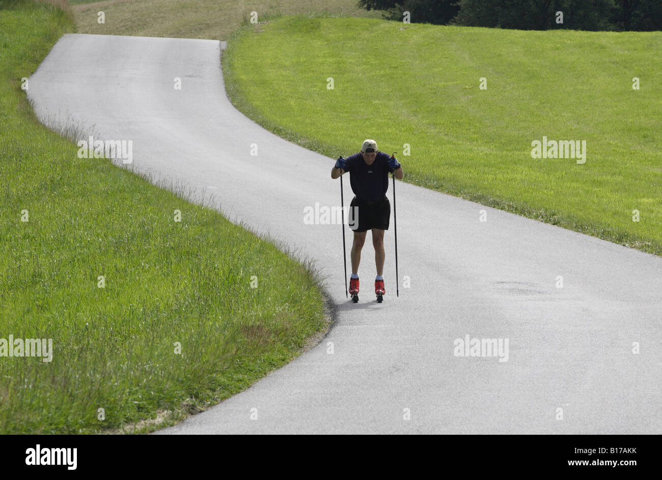 Summer training of a nordic skier on a paved road. Stock Photo