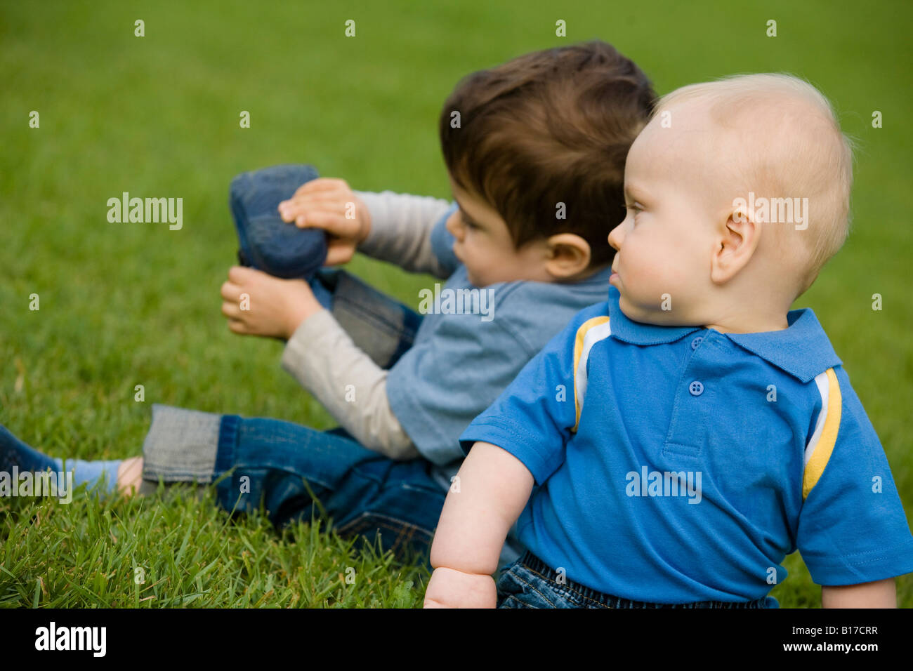 Two boys sitting on grass Stock Photo - Alamy