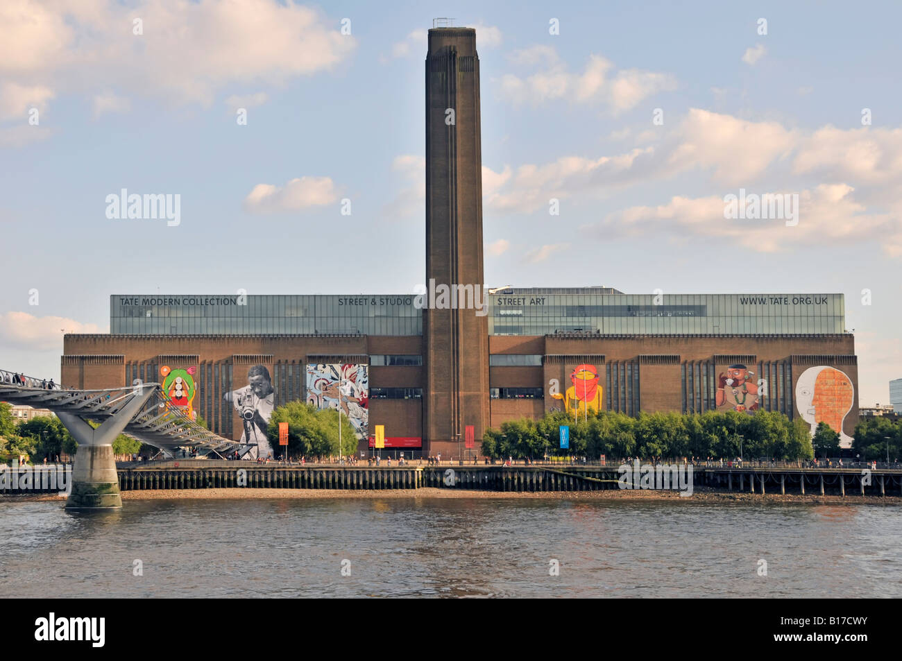 View across River Thames with Millennium Bridge & Tate Modern street art display on walls of refurbished redundant Bankside power station England UK Stock Photo