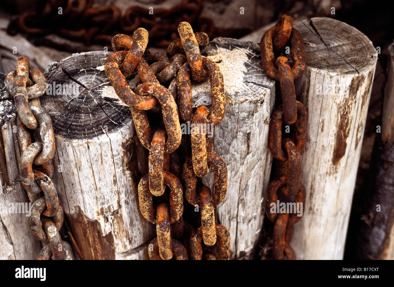 Rusty chains on wooden posts Stock Photo - Alamy