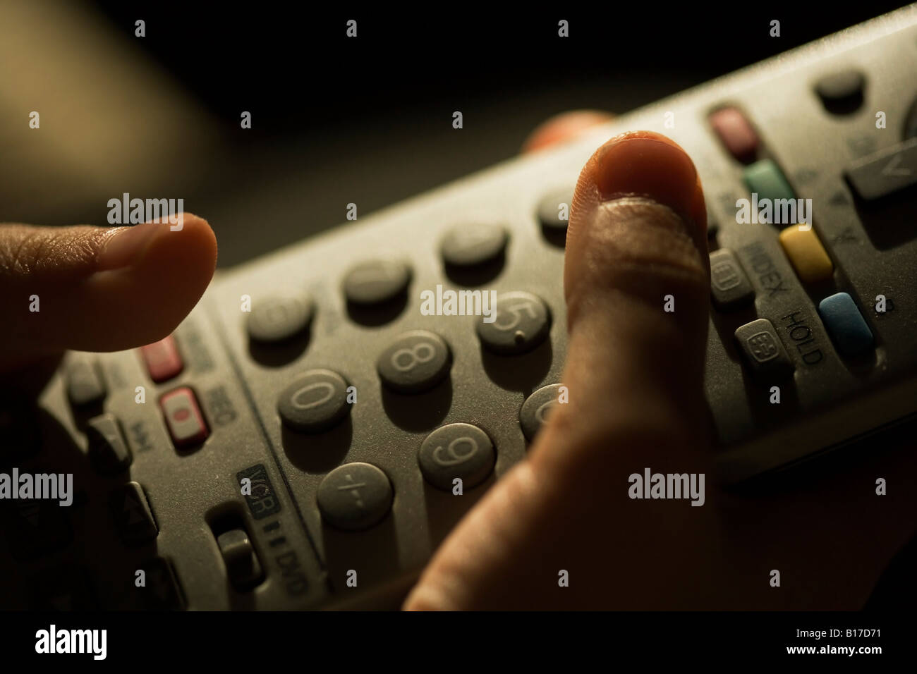 TV remote control in hands of six year old boy Stock Photo