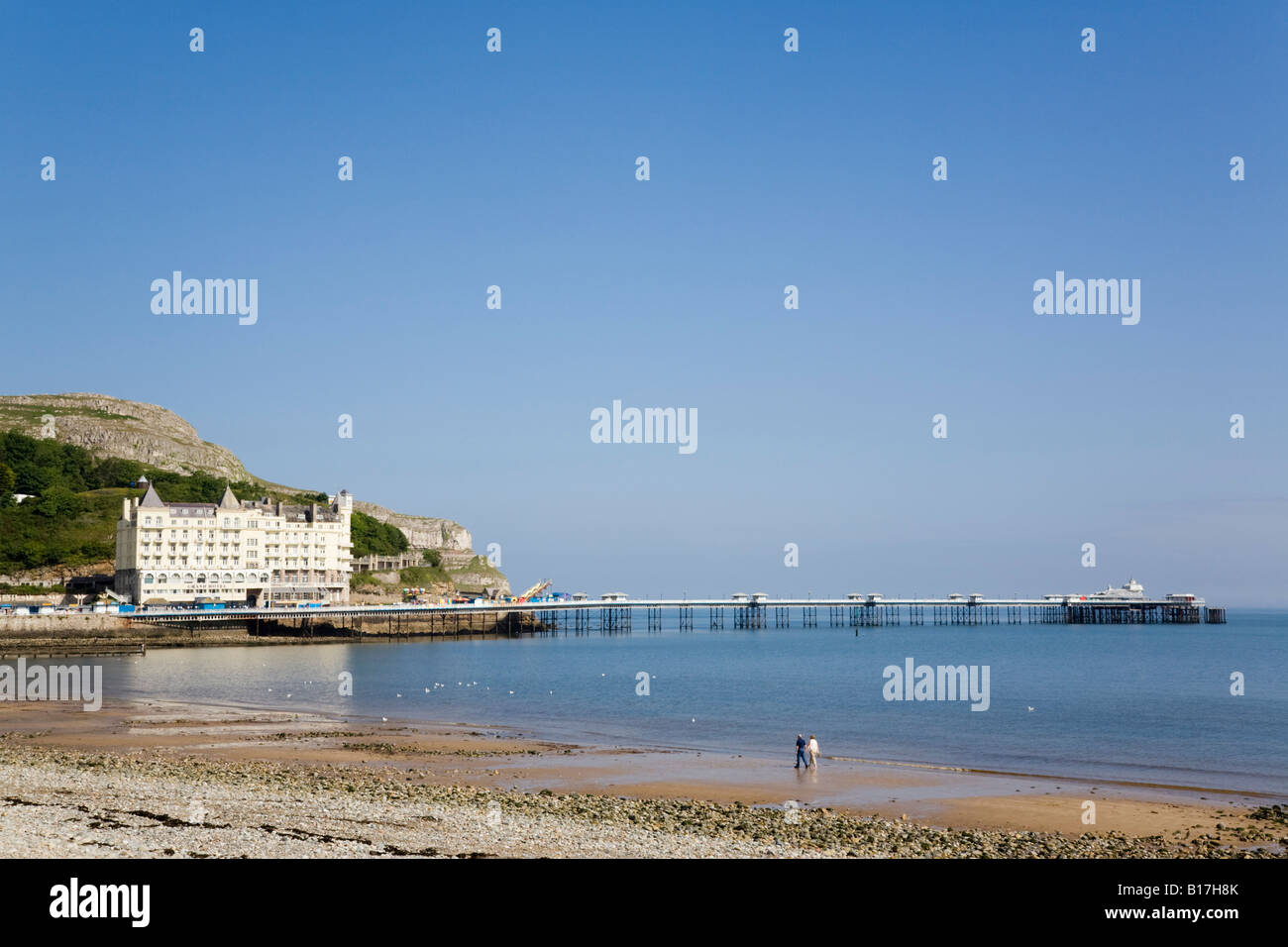 Quiet North Beach with The Grand Hotel and pier in tourist resort on Welsh coast  Llandudno North Wales UK Stock Photo