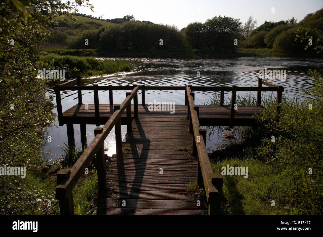 wooden jetty in evening reflected sunlight on the river quoile part of the quoile pondage national nature reserve county down Stock Photo
