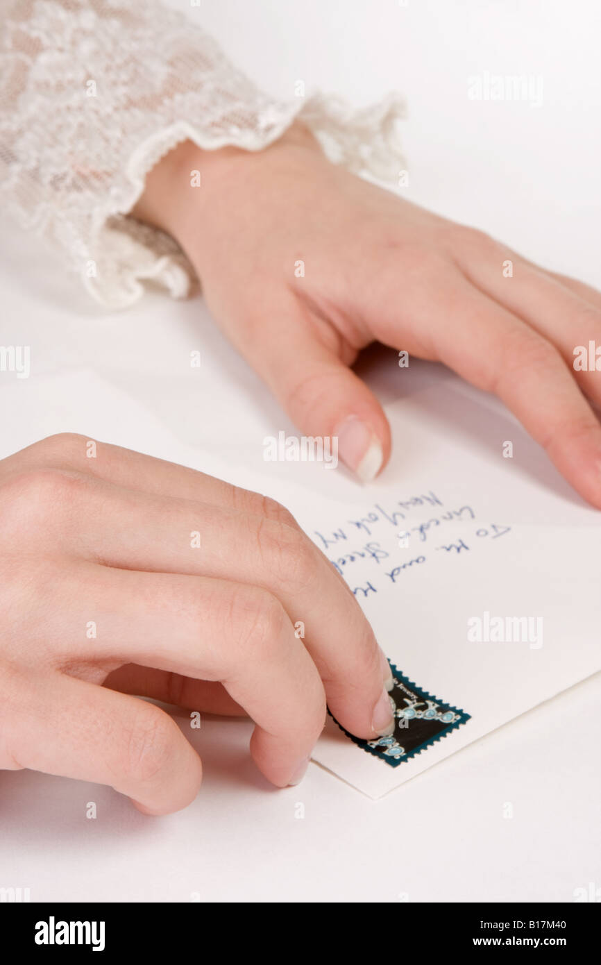 Secretary sticking a stamp on an envelope - the address is the most common one in the US Stock Photo