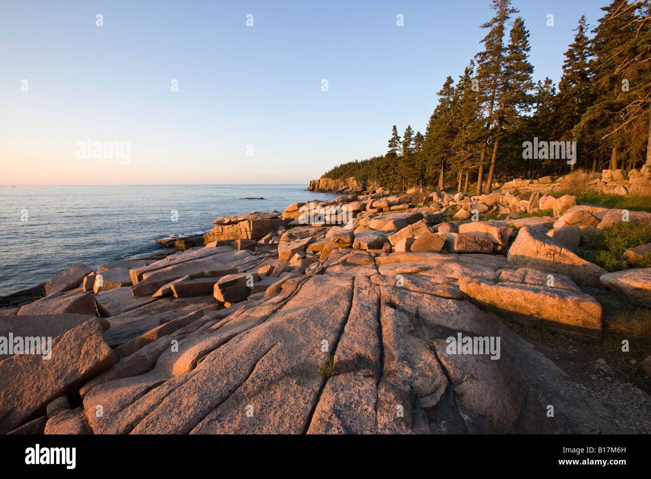 Golden sunrise illuminates the rocky coast at Acadia National Park ...