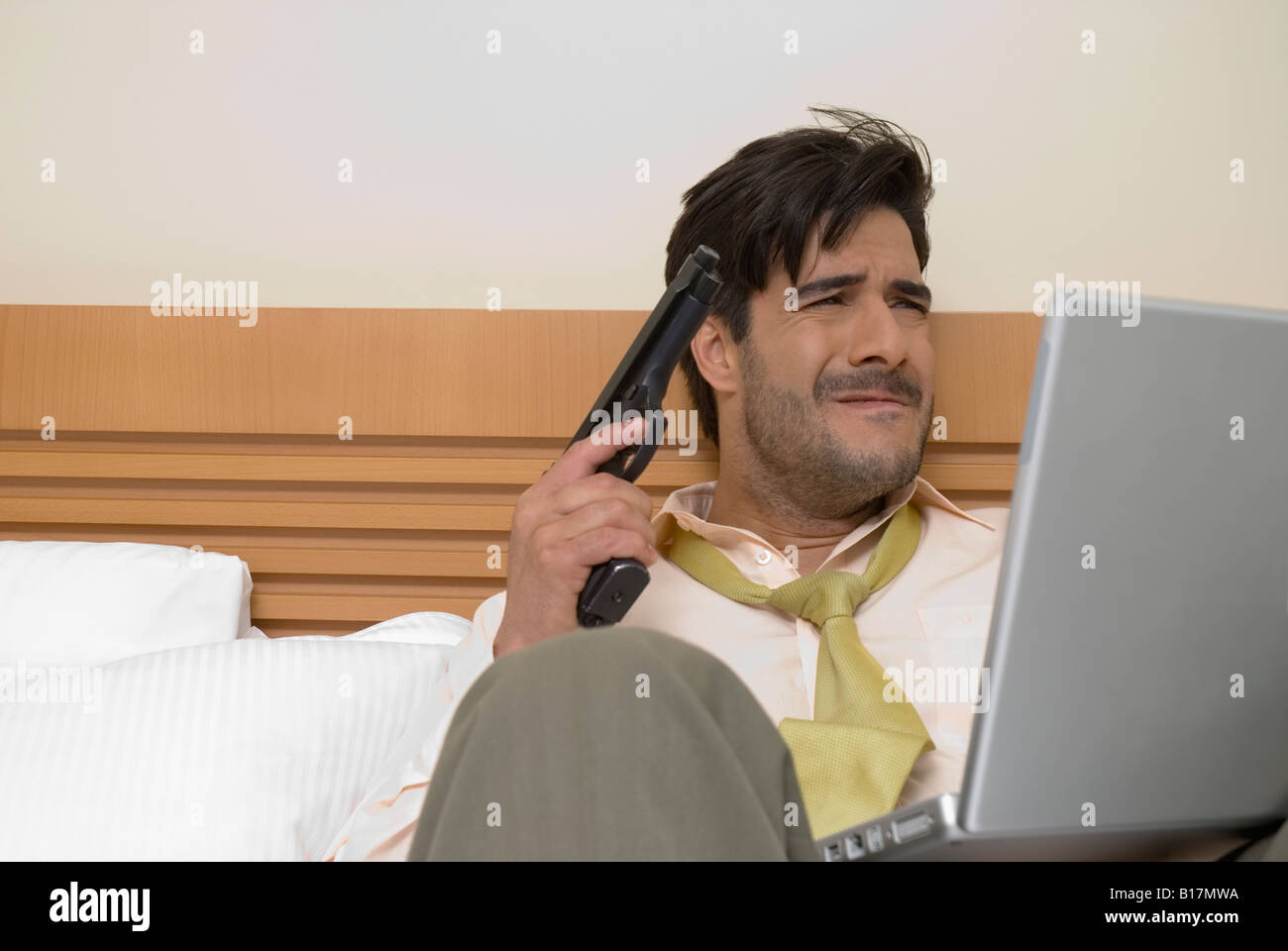 Hispanic businessman holding gun and laptop Stock Photo Alamy