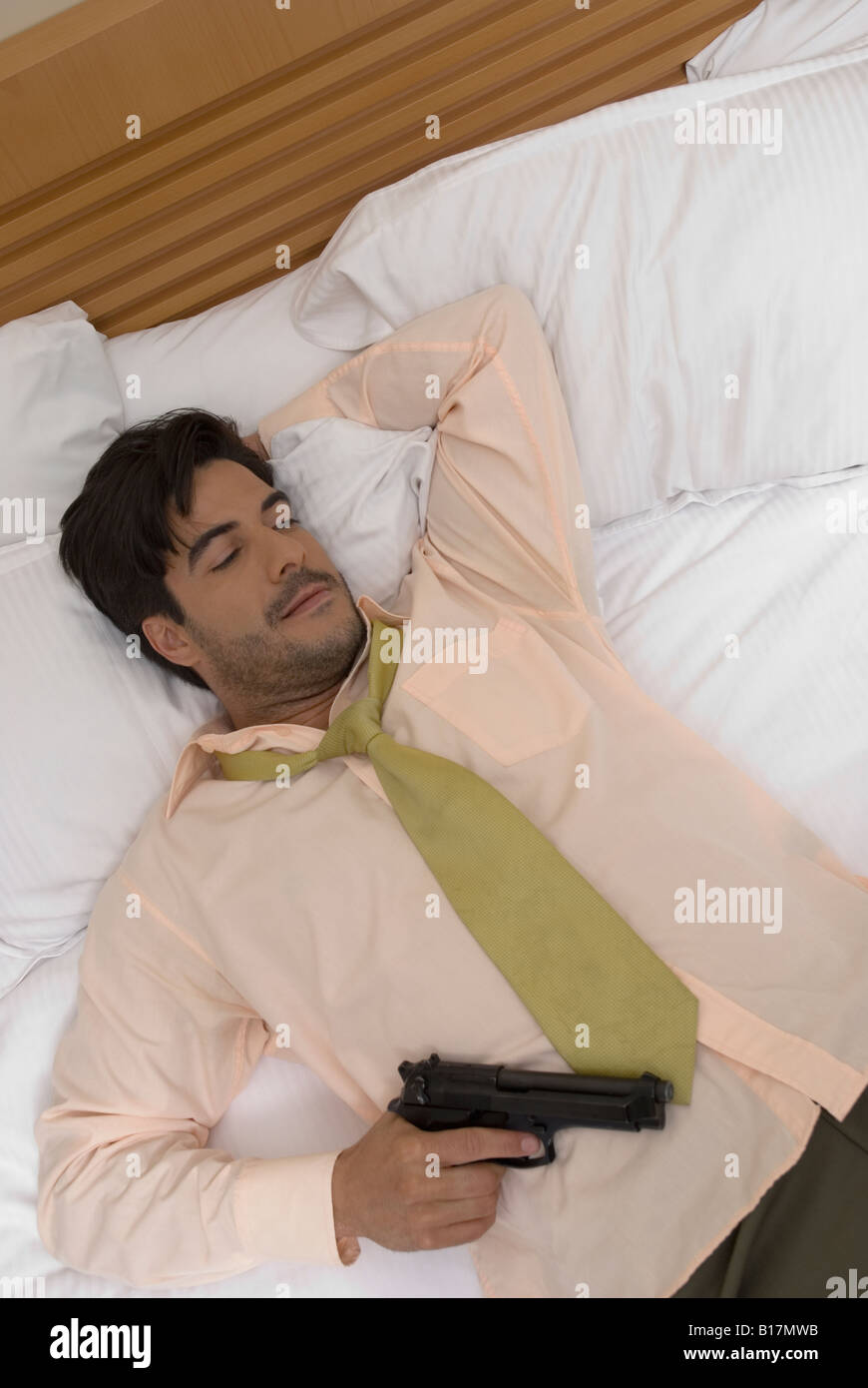 Man bed holding gun hires stock photography and images Alamy