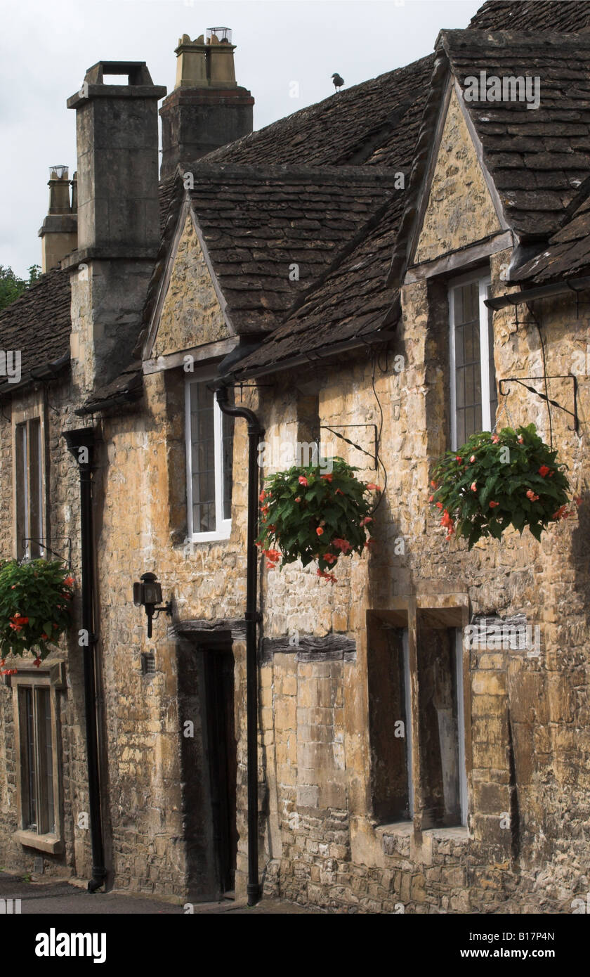 Terraced cottages with hanging baskets in Castle Combe, The Cotswolds, Wiltshire, England, UK Stock Photo