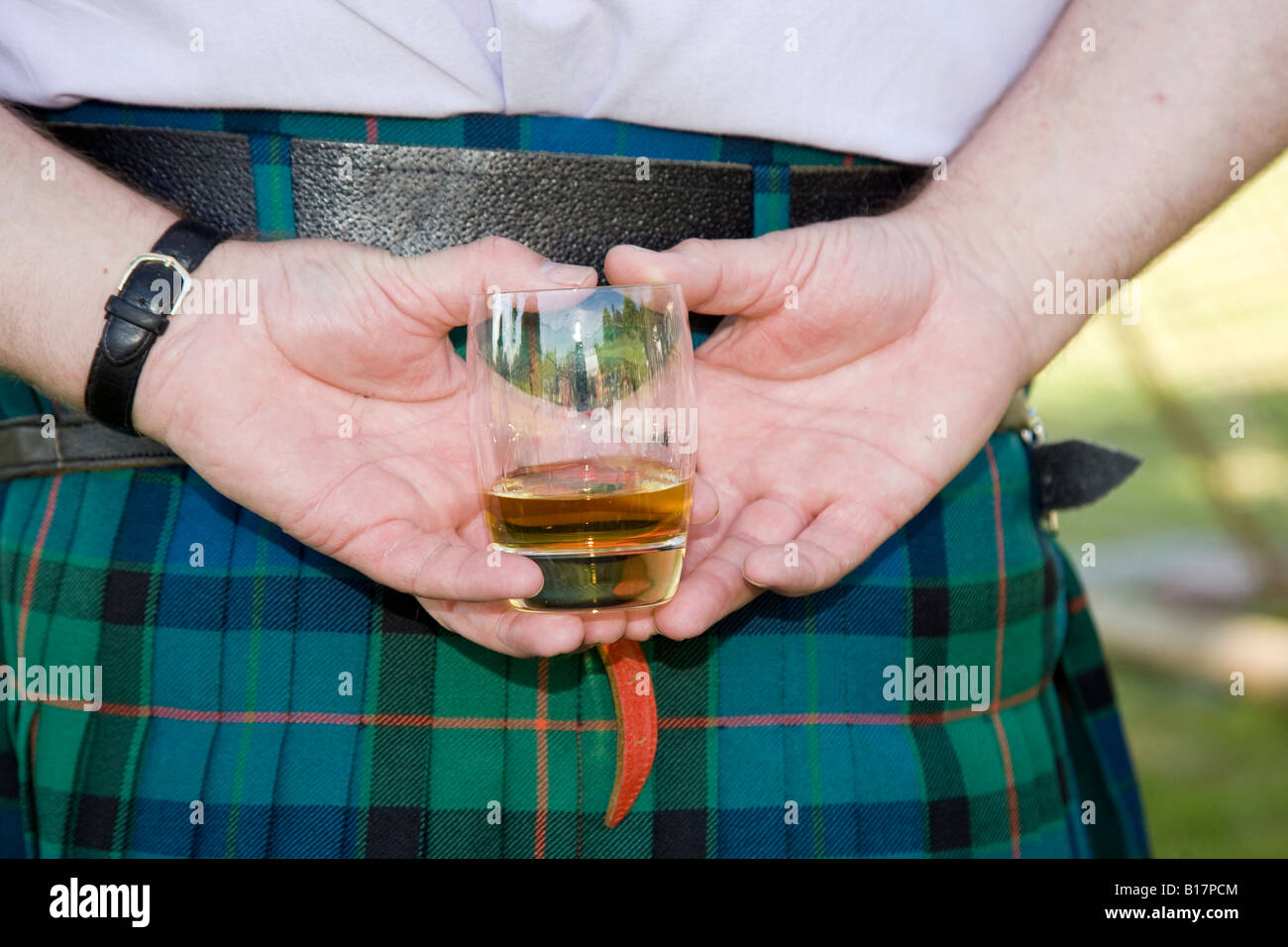 Scottish Highland Games - Scotch whisky or whiskey glass held behind back of kilt wearing scotsman, Scotland uk Stock Photo
