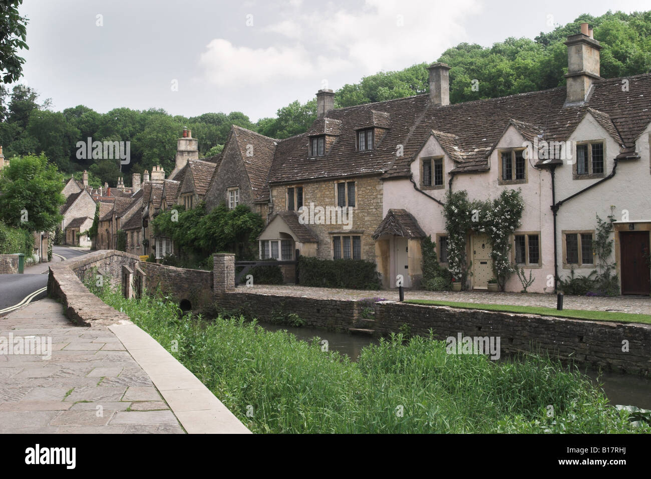 Picturesque cottages overlooking By Brook bridge and the river which runs through Castle Combe, The Cotswolds, Wiltshire, England, UK Stock Photo