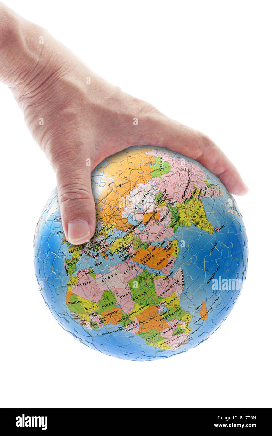 Hand gripping globe showing Africa Europe and Asia Stock Photo