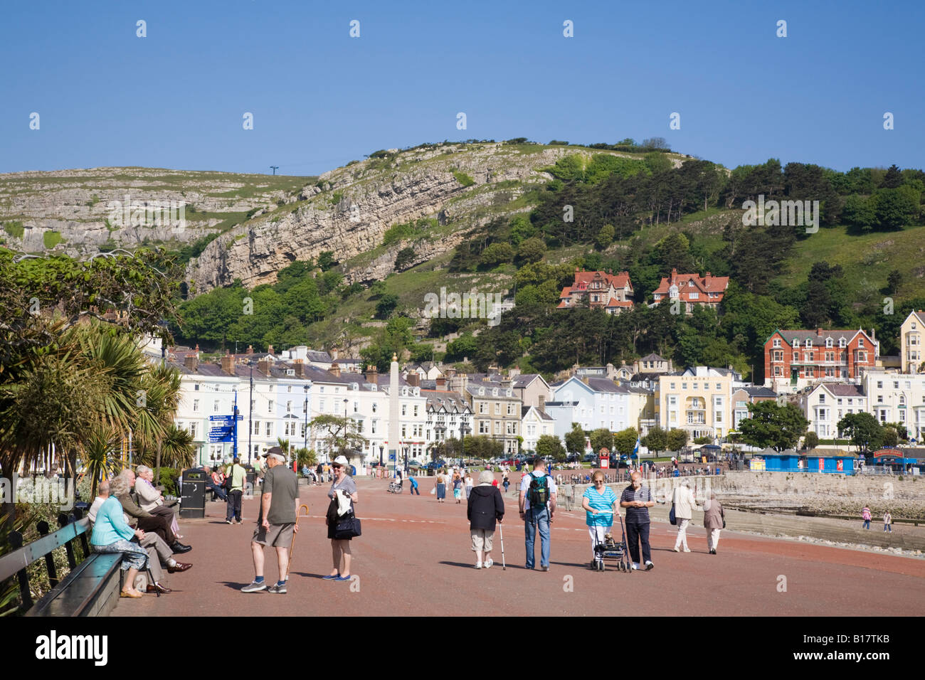 People strolling on North Parade promenade on seafront in elegant 19th century Victorian seaside holiday resort. Llandudno North Wales UK Britain Stock Photo