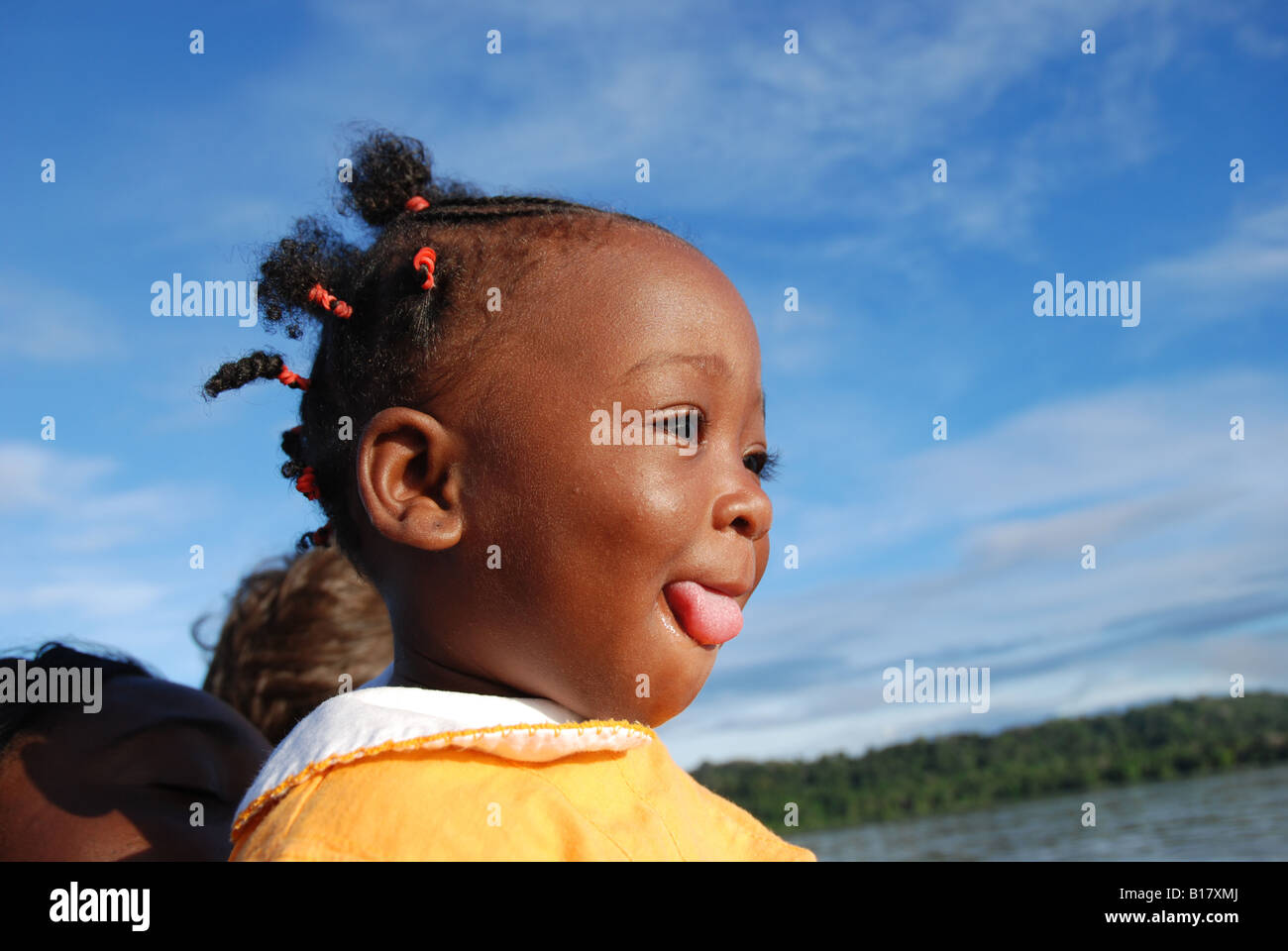 beautiful little girl tongue" young black girl tongue out down the river on a canoe in south America  Stock Photo - Alamy