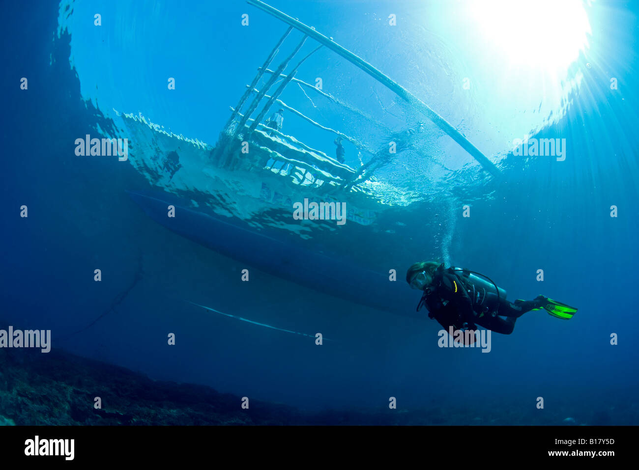 scuba diver under outrigger diving boat Maolboal Cebu Philippines Stock Photo