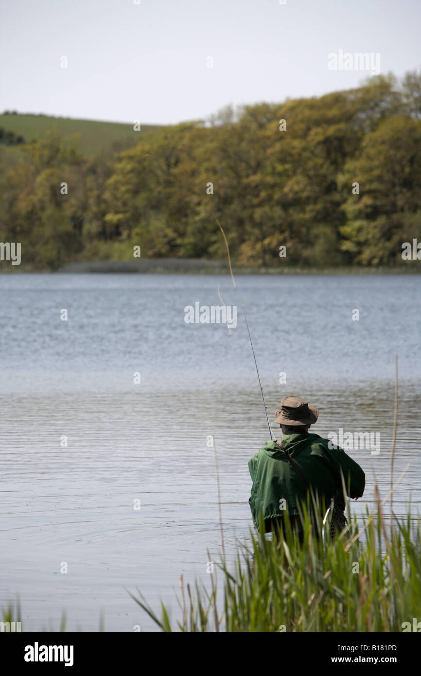 man casting flyfishing rod and line in a lake in county down northern ireland Stock Photo