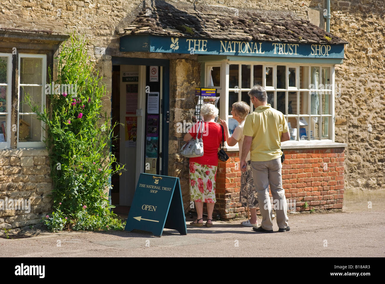 Tourists visiting a shop in the lovely English village of Lacock viewed from public highway Stock Photo