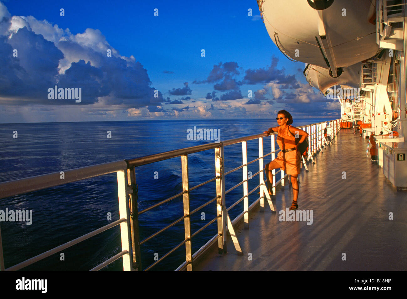 Woman on cruise ship deck near Cosmoledo group in the Indian Ocean Stock Photo