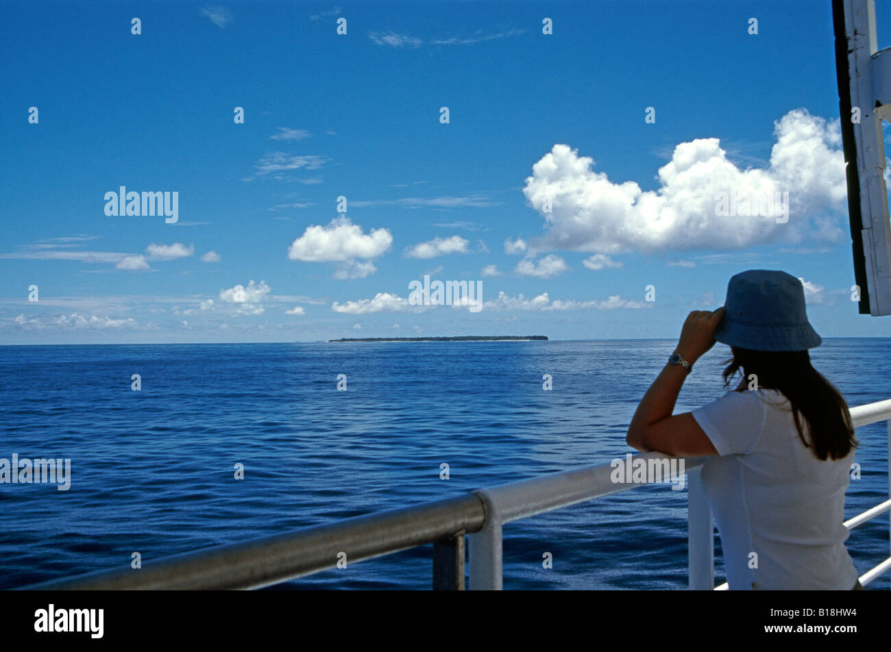 Tourist on cruise ship looking at the remote Alphonse Islands, Seychelles, Indian Ocean Stock Photo