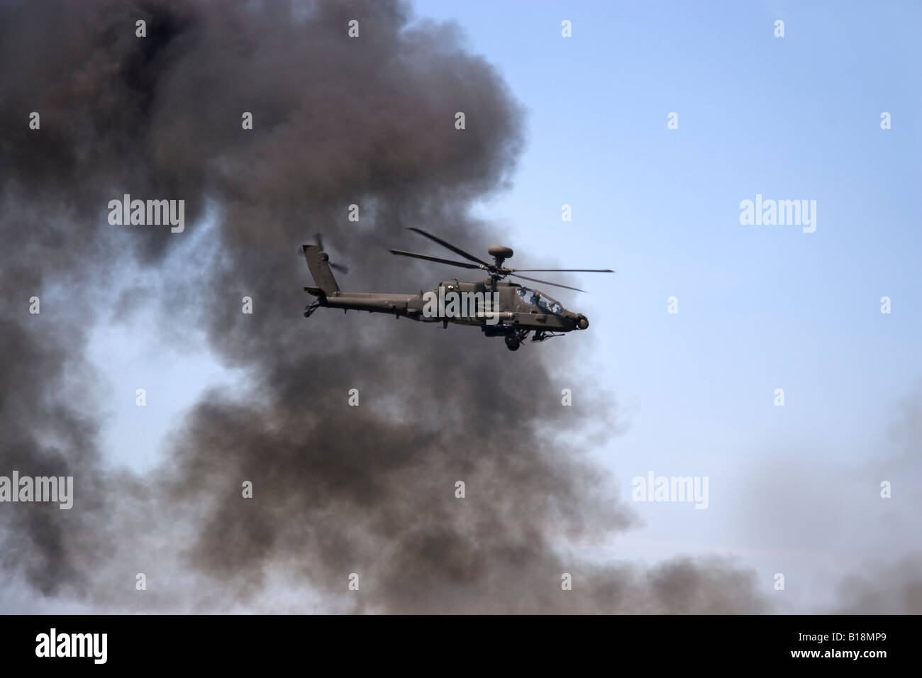 Smoke rising during a simulated attack by an WAH 64 Apache attack helicopter of the British Army during the Biggin Hill Airshow Stock Photo