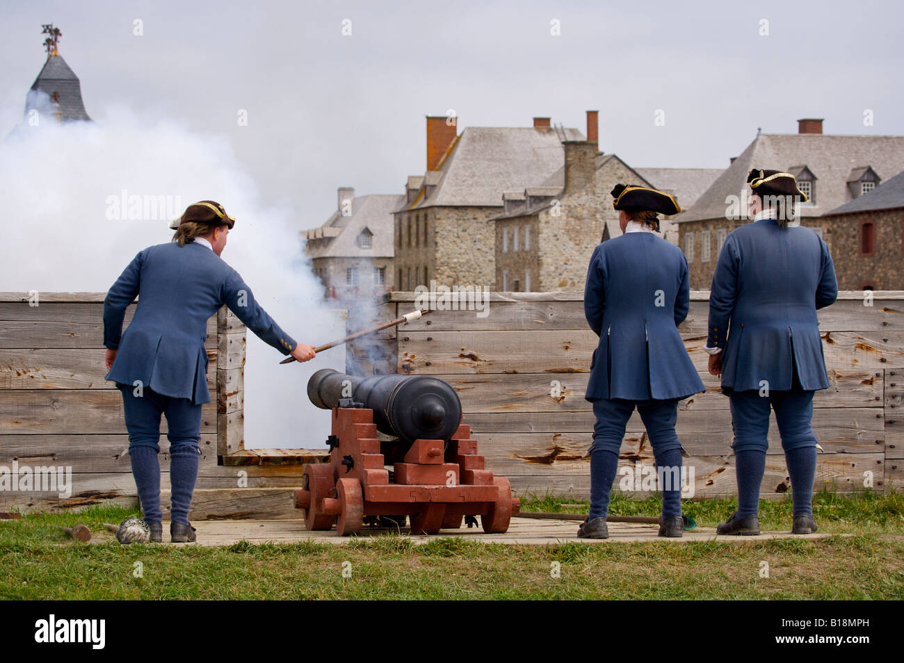Soldier firing the cannon gun along the Quay  at the Fortress of Louisbourg, Louisbourg National Historic Site, Highway 22, Fleu Stock Photo