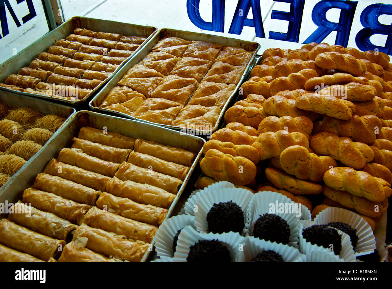 Display case of assorted fancy baklava, filo desserts, rum balls, and sweet almond rolls in a Greek bakery Stock Photo