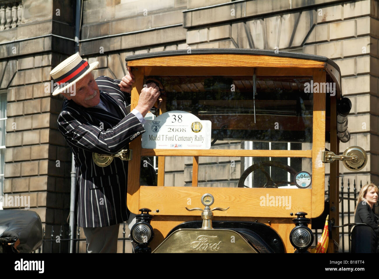A driver cleaning the windscreen of his 1915 Model T Ford shooting brake, Edinburgh Stock Photo