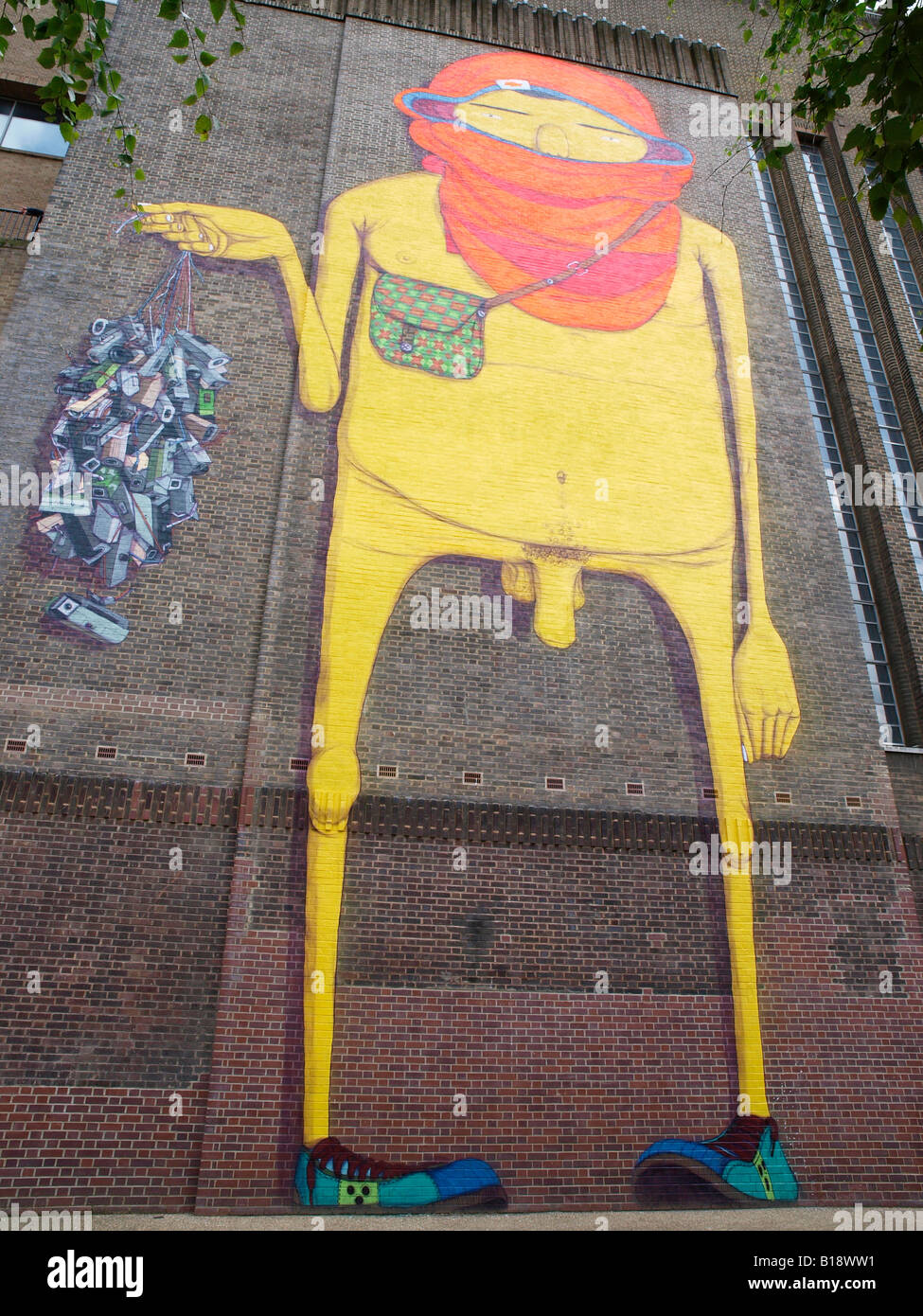 Os Gemeos trademark yellow figure painted on the Tate Modern London Stock Photo