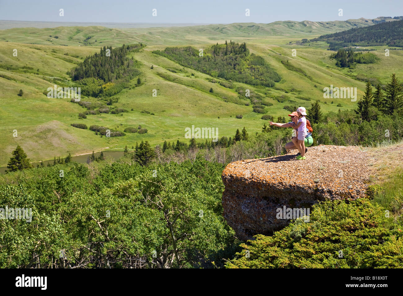 Young mother and daughter enjoy view at the Conglomerate Cliffs, Cypress Hills Interprovincial Park, Saskatchewan, Canada. Stock Photo