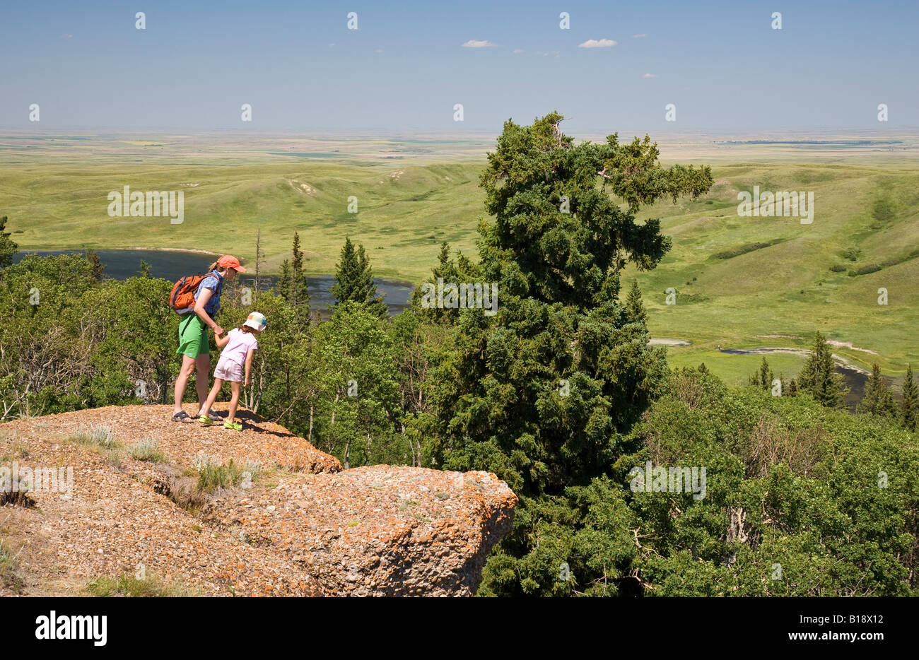 Young mother and daughter enjoy view at the Conglomerate Cliffs, Cypress Hills Interprovincial Park, Saskatchewan, Canada. Stock Photo