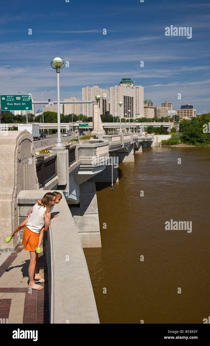 Young mother and daughter enjoy view of Red River from Norwood Bridge, Winnipeg, Manitoba, Canada. Stock Photo