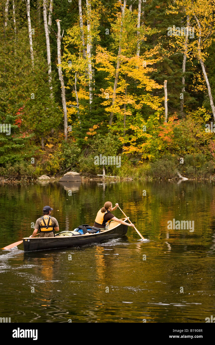 Young couple canoe on Oxtongue Lake in autumn, Mukoka, Ontario, Canada. Stock Photo