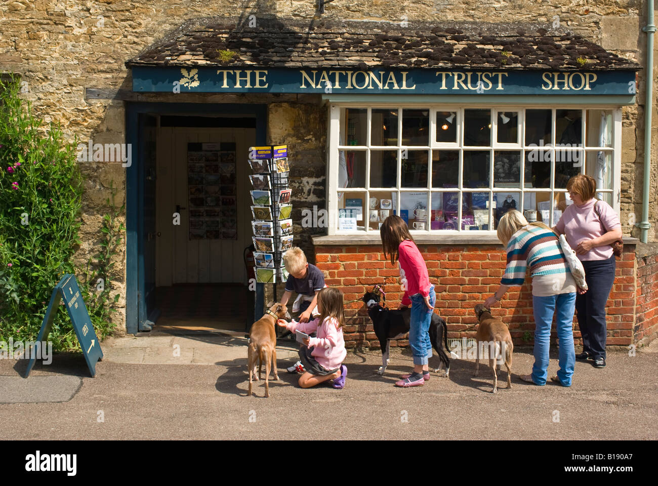 Three pet dogs attract attention from passing tourists in Lacock Stock Photo
