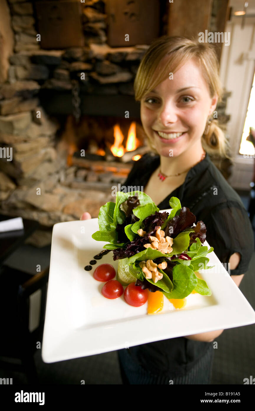 Female server at Tomato,Tomato restaurant, displays fresh Cashew salad