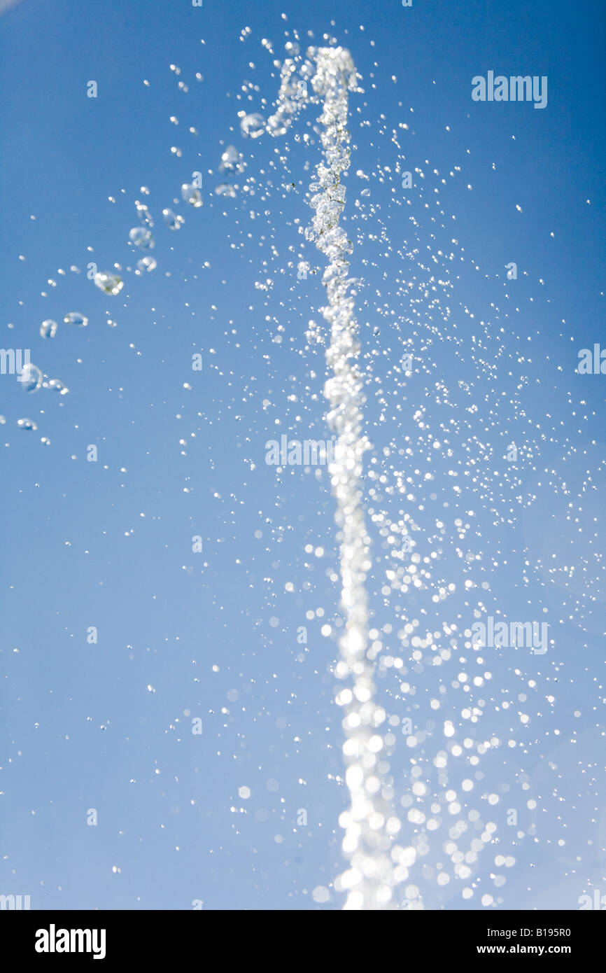 Jet of water frozen against a bright blue sky. Stock Photo