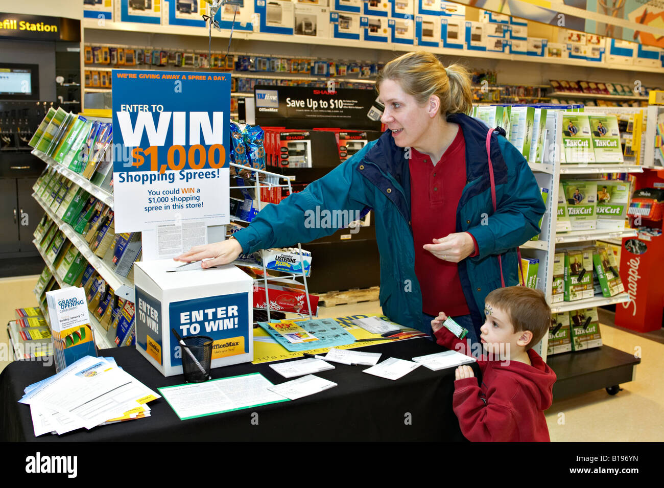 EVENTS Algonquin Illinois Woman with young boy place sweepstakes entry form in box at OfficeMax retail store grand opening Stock Photo