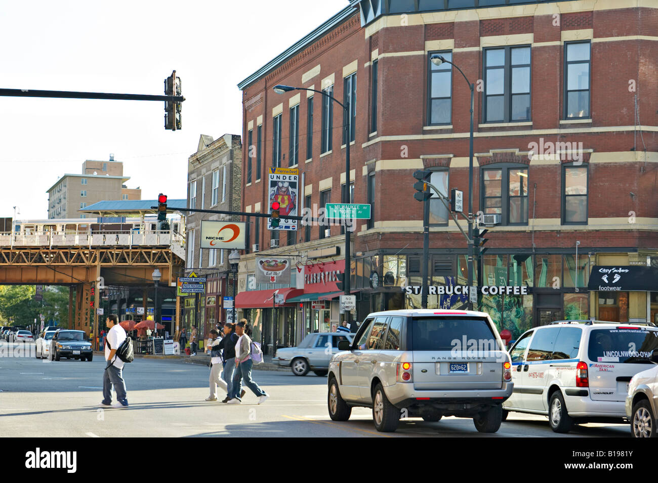 ILLINOIS Chicago Milwaukee Avenue and North Avenue intersection in Bucktown el train pedestrian and vehicular traffic stores Stock Photo