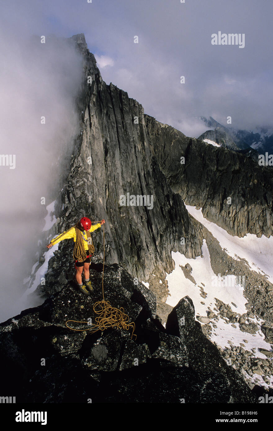 Senja Palonen coils a rope on the summit of North Nesakwatch Spire after climbing the North Ridge route, Chilliwack Valley, Brit Stock Photo